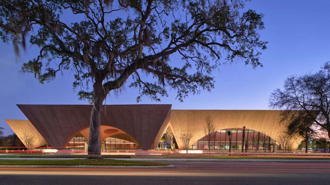 The pavilions of Winter Park Library cantilever as they rise; the forms of the library and event pavilions are accented by shielded in-grade uplights so as not to distract from the architecture. By contrast, the porte coch&egrave;re (foreground) features internal uplighting.