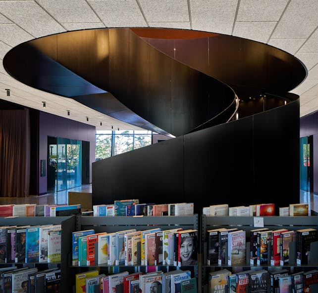 A blackened steel staircase features internal handrail lighting to safely guide visitors.